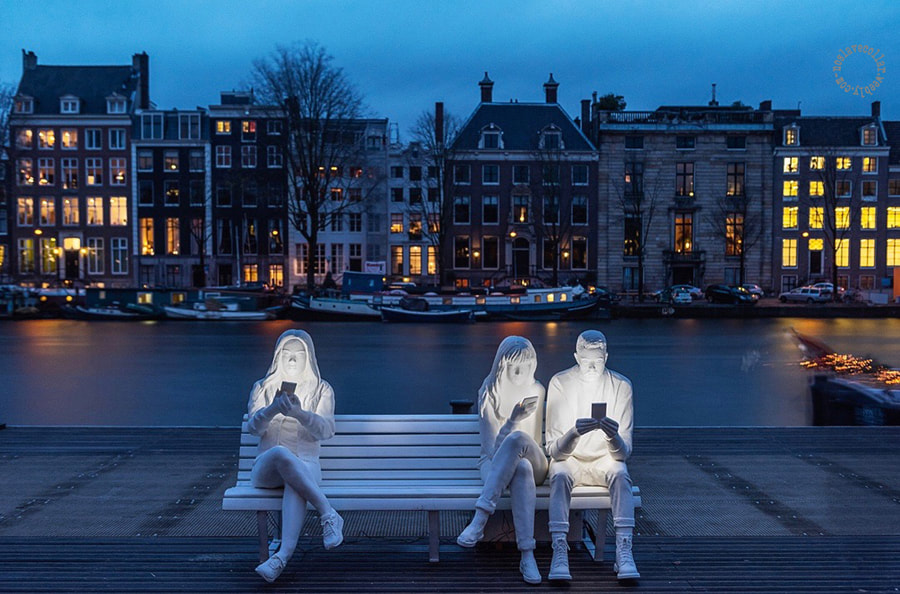 "Absorbés par la lumière" de Gali May Lucas est une sculpture exposée à Amsterdam, pour mettre en évidence l'obsession et la dépendance aux téléphones portables.