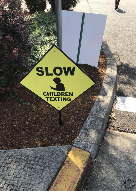 Panneau sur un passage piéton: "Ralentissez, les enfants envoient des SMS".