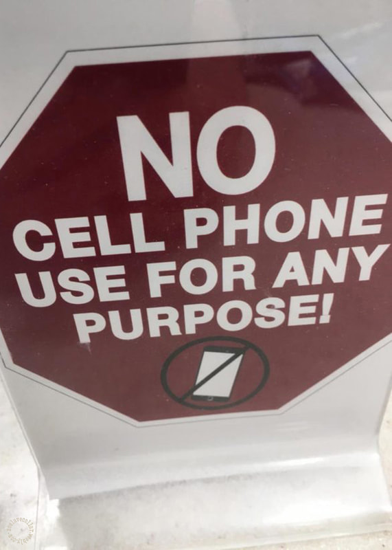 Panneau dans un vestiaire: "AUCUNE utilisation du téléphone portable à quelque fin que ce soit!"