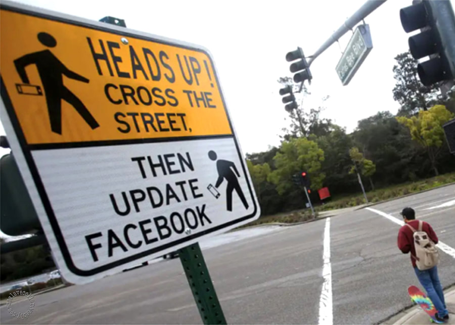 Panneau: "Relevez la tête! Traversez la rue. Ensuite mettez Facebook à jour"